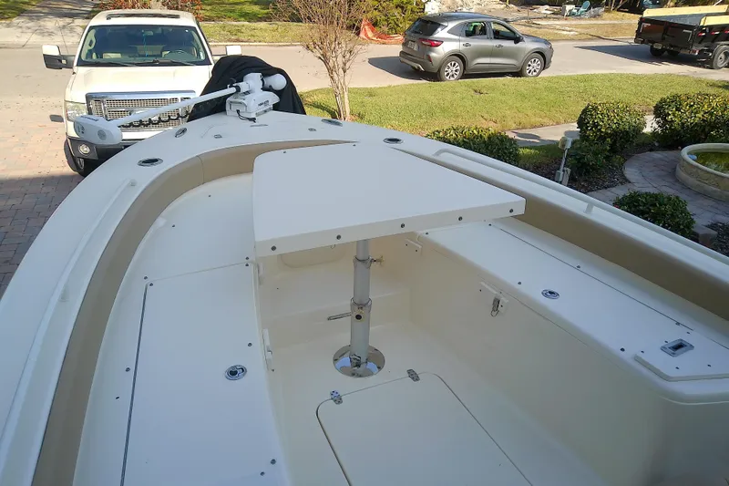 Slide: The Image of 2018 Scout 251 XSS boat with deck table, parked in residential driveway. - 33