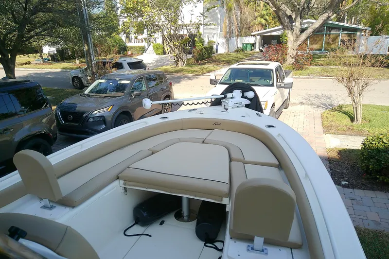 Slide: The Image of 2018 Scout 251 XSS boat parked in a residential driveway with cars nearby. - 35