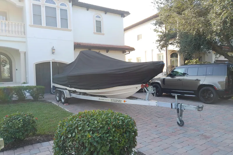 Slide: The Image of Covered 2018 Scout 251 XSS boat on trailer, parked beside a house and SUV. - 4
