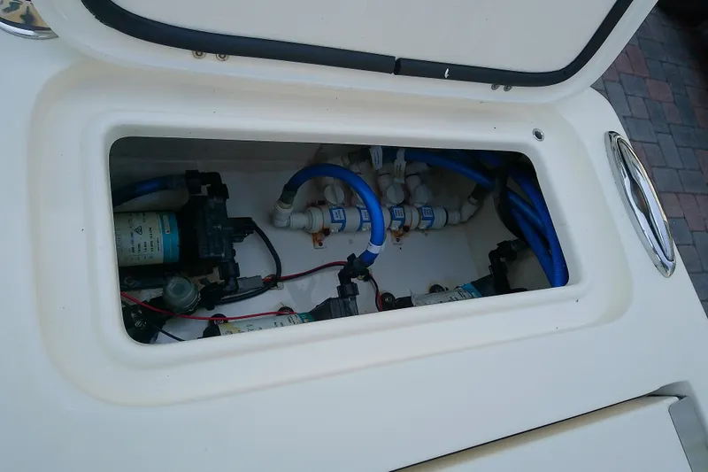 Slide: The Image of Open compartment of a 2018 Scout 251 XSS boat showing internal plumbing and wiring. - 42