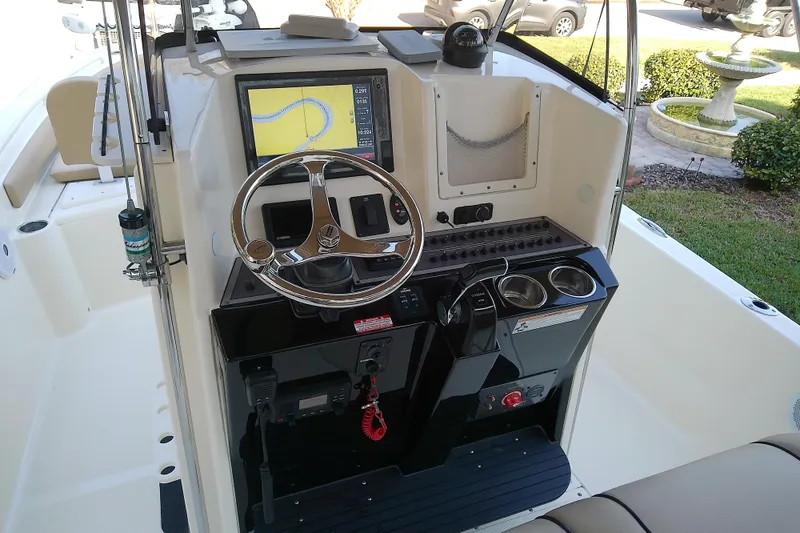Slide: The Image of 2018 Scout 251 XSS boat dashboard with steering wheel and navigation display. - 48