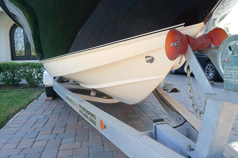Slide: The Image of 2018 Scout 251 XSS boat on trailer, parked on brick driveway. - 5