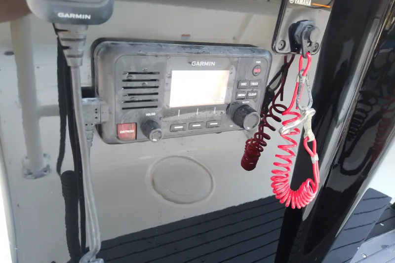 Slide: The Image of Garmin marine radio on 2018 Scout 251 XSS boat dashboard with red coiled cord. - 50