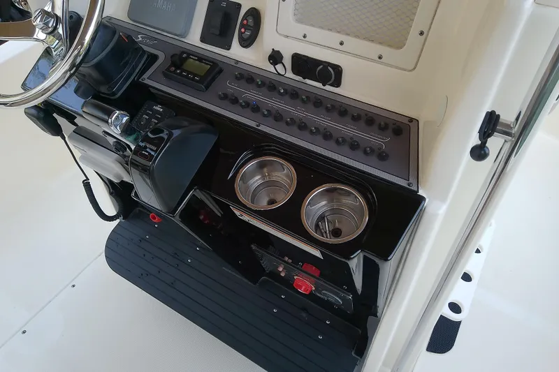 Slide: The Image of 2018 Scout 251 XSS boat console with controls, switches, and cup holders. - 54