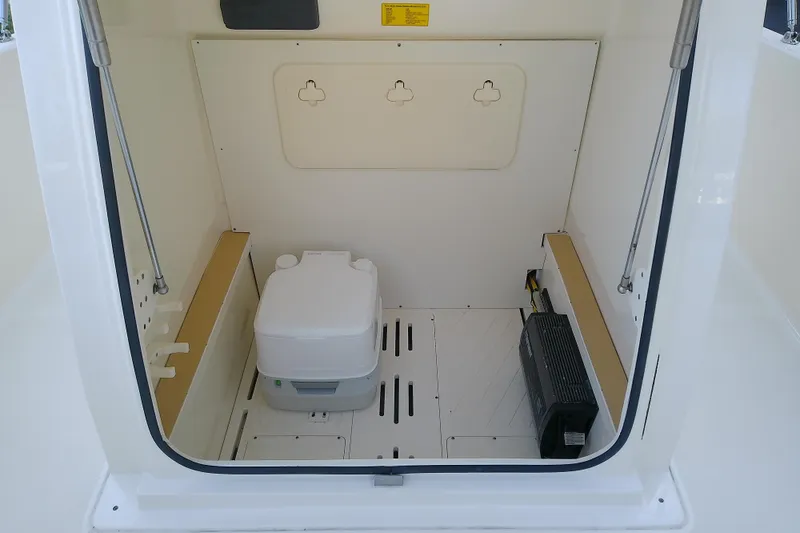 Slide: The Image of 2018 Scout 251 XSS boat interior with portable toilet and storage compartment. - 57