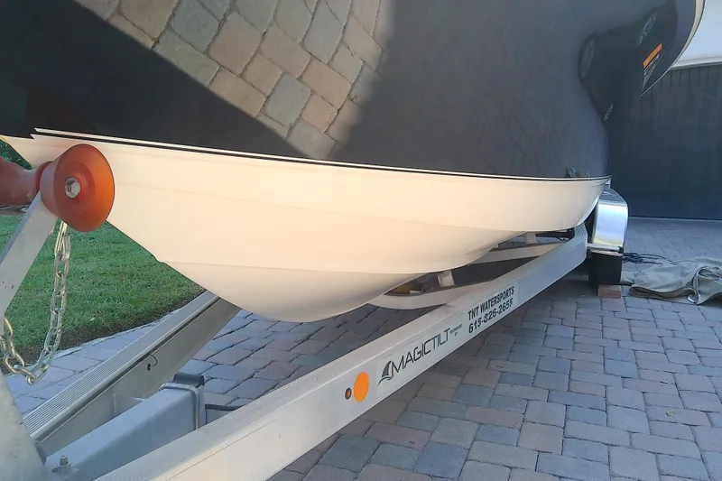 Slide: The Image of 2018 Scout 251 XSS boat on Magic Tilt trailer, parked on brick driveway. - 6