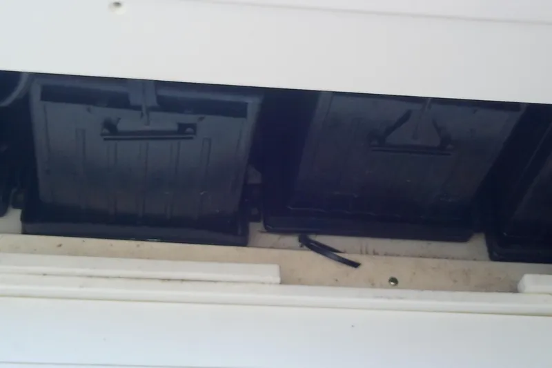 Slide: The Image of Battery compartment of a 2018 Scout 251 XSS boat, showing black battery boxes. - 61