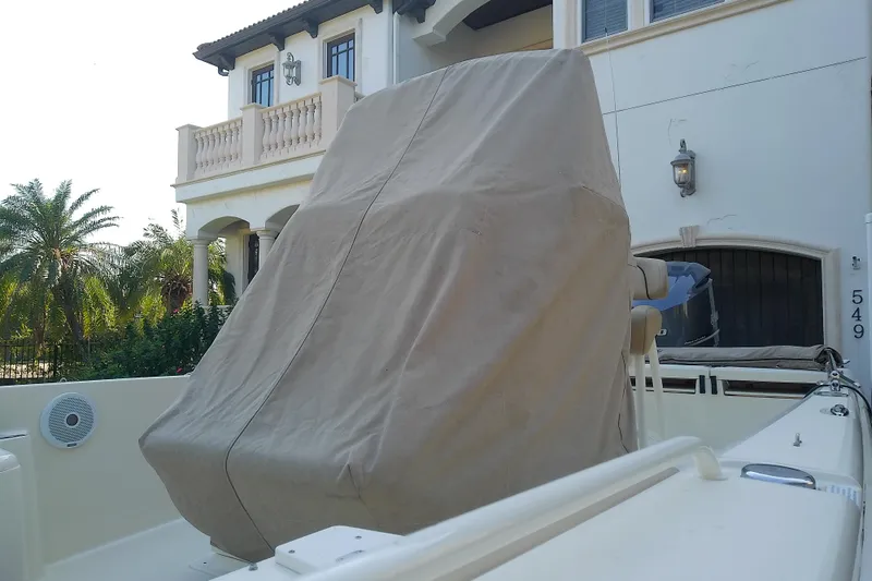 Slide: The Image of 2018 Scout 251 XSS boat with covered console, near a luxury home. - 72