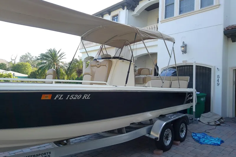 Slide: The Image of 2018 Scout 251 XSS boat on trailer, parked in front of a house. - 74