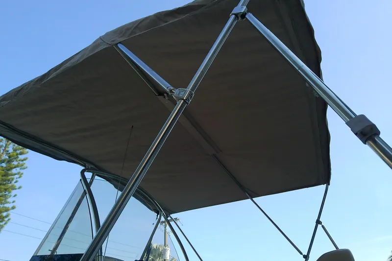Slide: The Image of 2018 Scout 251 XSS boat with bimini top against clear blue sky. - 80