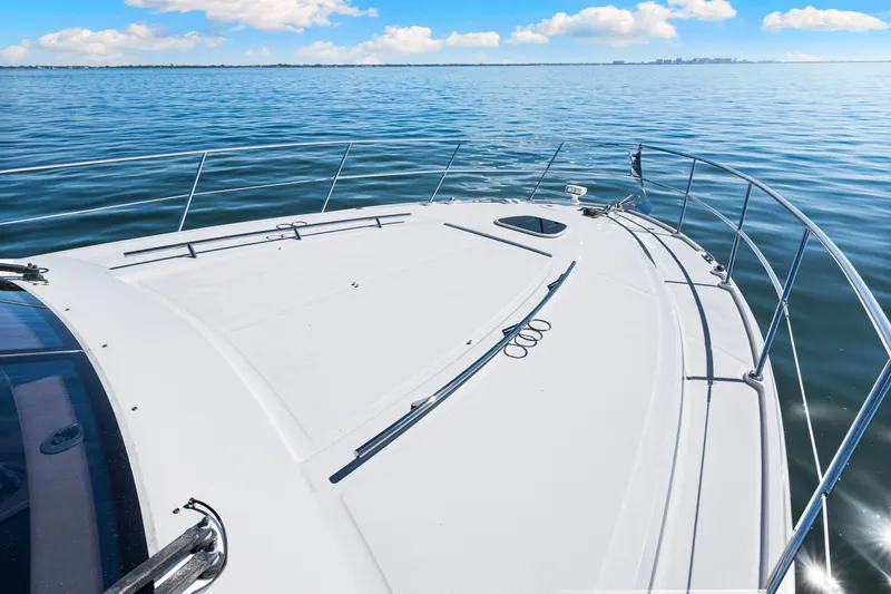 Slide: The Image of 2016 Sea Ray 510 Sundancer yacht cruising on calm blue waters under a clear sky. - 30