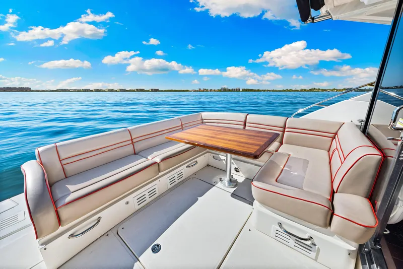 Slide: The Image of Luxurious seating area on 2016 Sea Ray 510 Sundancer yacht, with ocean view and blue sky. - 38