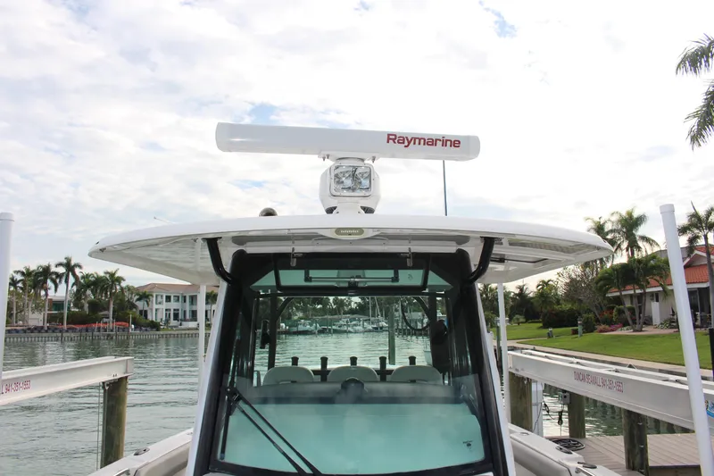 Slide: The Image of 2020 Boston Whaler 350 Outrage docked, featuring Raymarine equipment, with waterfront homes in the background. - 11
