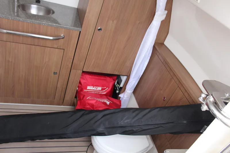 Slide: The Image of 2020 Boston Whaler 350 Outrage interior with sink, storage, and red safety gear. - 19