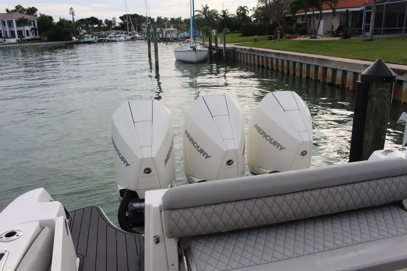 Slide: The Image of 2020 Boston Whaler 350 Outrage with triple Mercury engines docked by waterfront homes. - 6