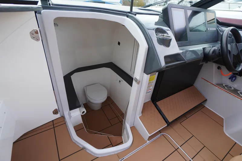 Slide: The Image of 2020 Aviara AV32 OB boat interior with helm and compact bathroom. - 32