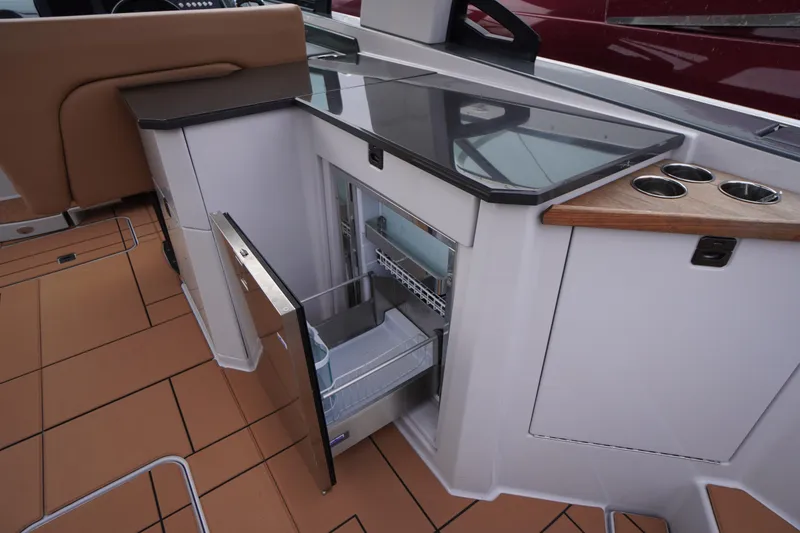 Slide: The Image of 2020 Aviara AV32 OB boat interior with open mini fridge and sleek countertop. - 44