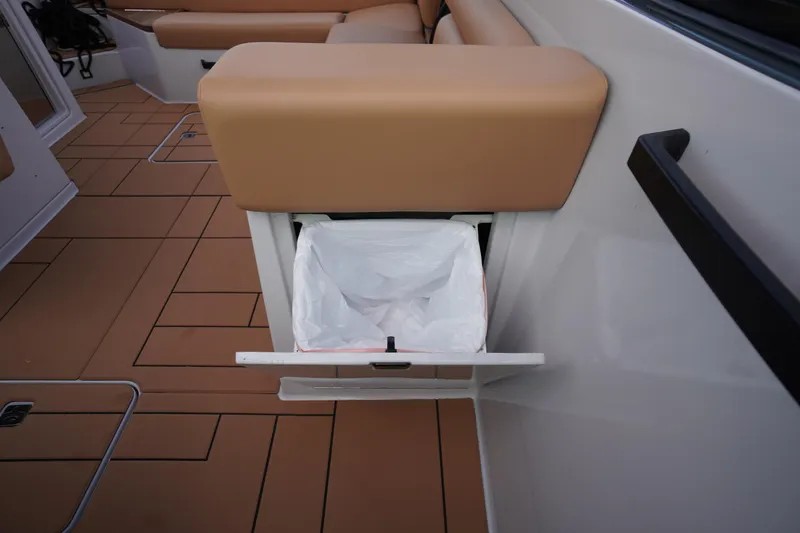 Slide: The Image of 2020 Aviara AV32 OB boat interior with built-in trash compartment and tan seating. - 48