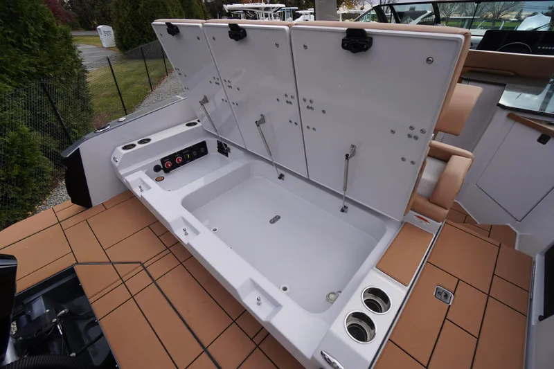 Slide: The Image of 2020 Aviara AV32 OB boat with open storage compartment and cup holders on deck. - 59