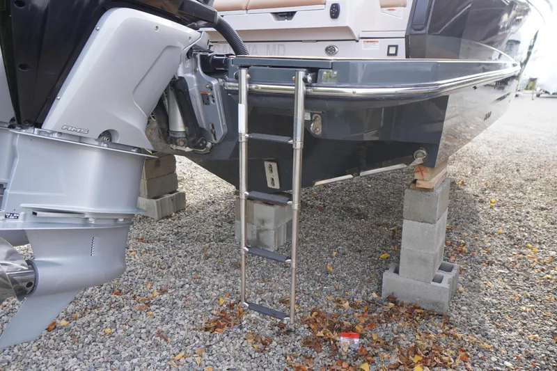 Slide: The Image of 2020 Aviara AV32 OB boat on blocks, showing outboard motor and ladder. - 77