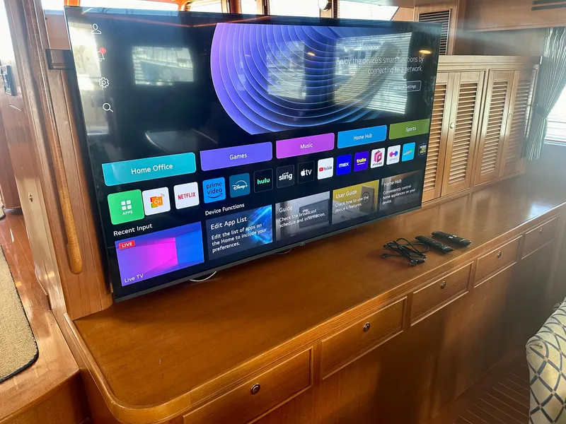 Slide: The Image of Smart TV on wooden cabinet inside 2005 Marlow Explorer 78 yacht, displaying streaming apps. - 11