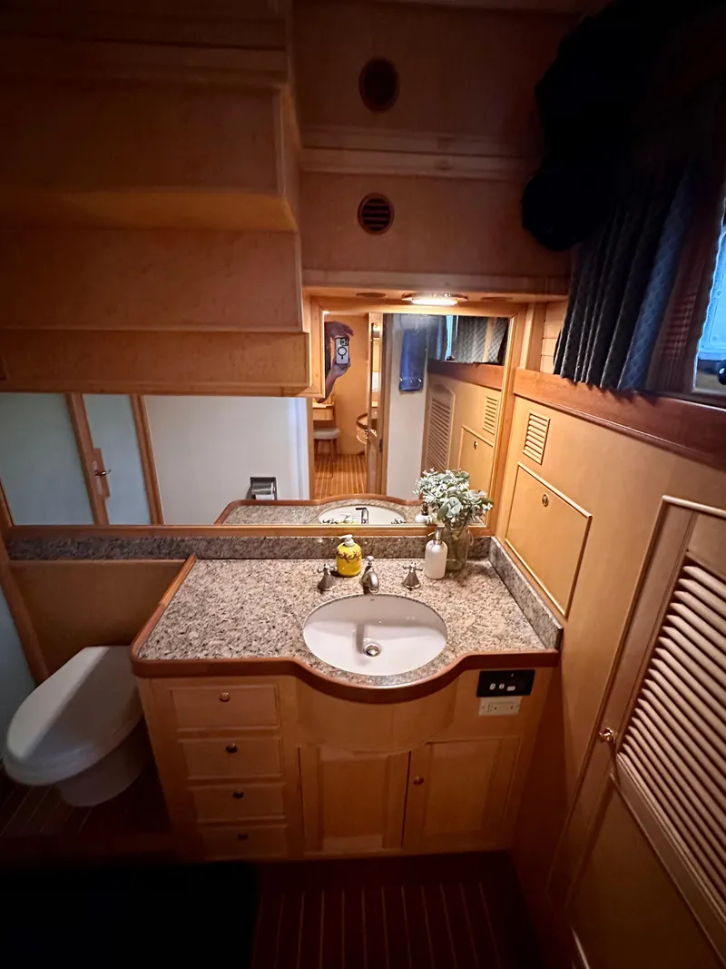 Slide: The Image of Luxurious bathroom in 2005 Marlow Explorer 78 yacht with granite countertop and wooden cabinetry. - 25