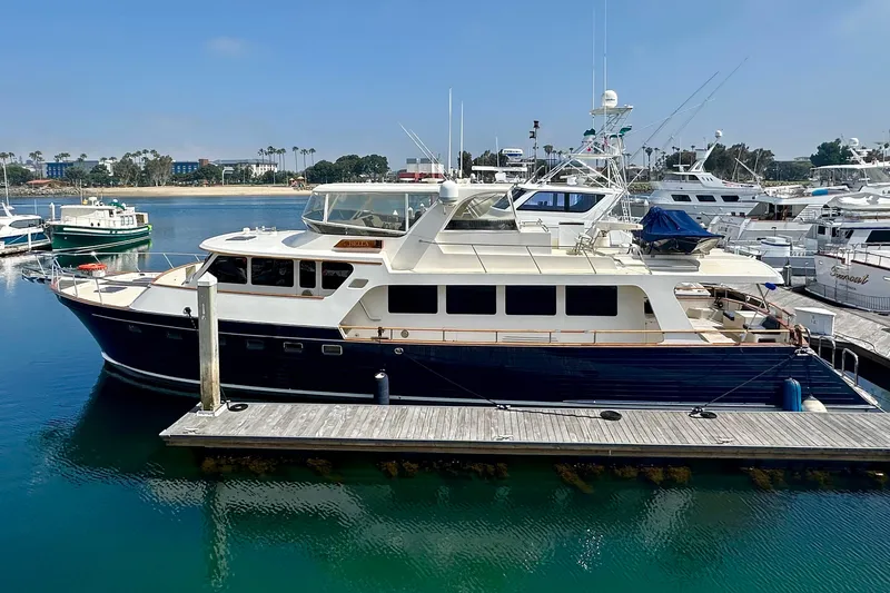 Slide: The Image of Luxury 2005 Marlow 78E yacht docked in a marina, surrounded by other boats. - 3