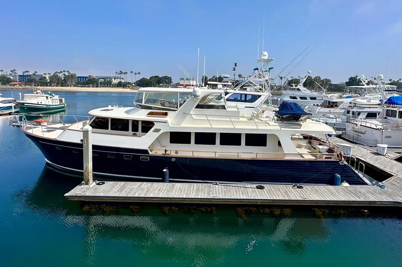 Slide: The Image of Luxury 2005 Marlow 78E yacht docked in a marina, surrounded by other boats. - 4