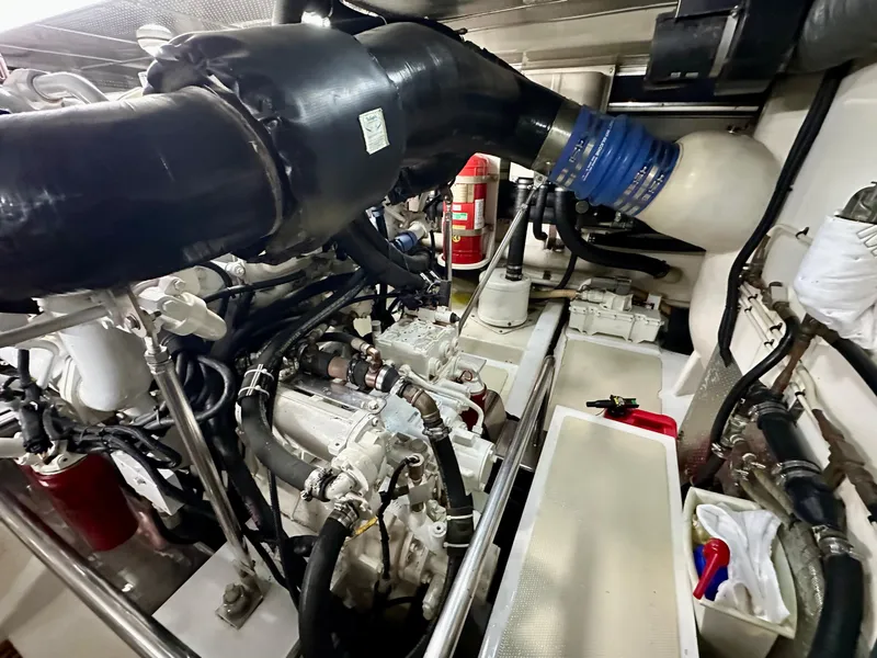 Slide: The Image of Engine room of a 2005 Marlow 78E yacht, featuring complex machinery and piping. - 46