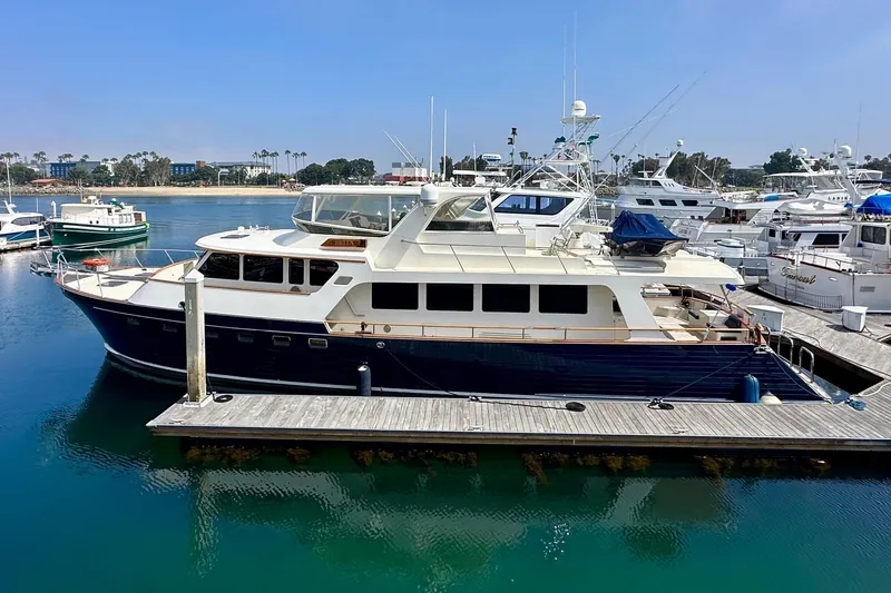 Slide: The Image of Luxury 2005 Marlow 78E yacht docked in a serene marina setting. - 48