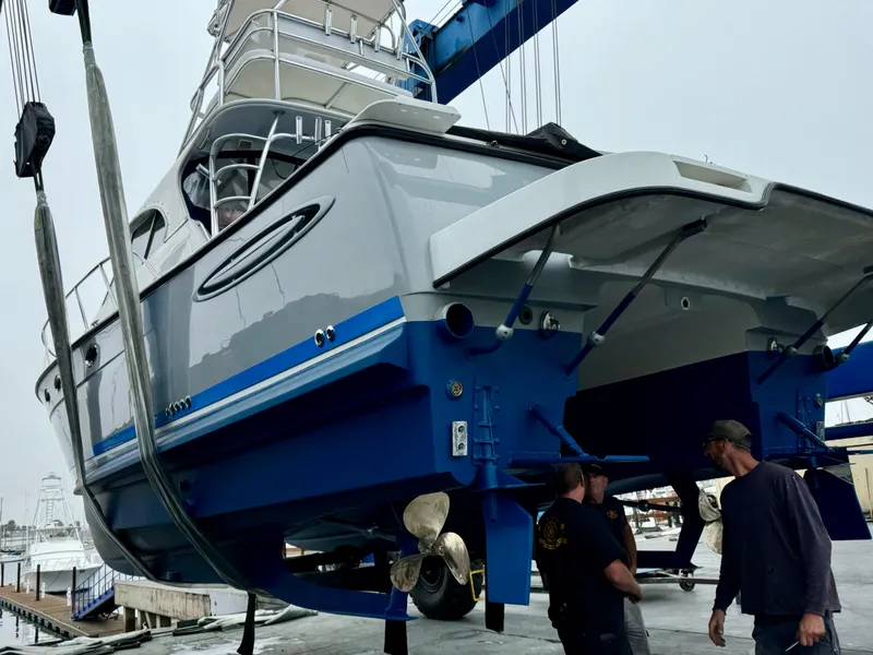 Slide: The Image of 2006 Glacier Bay 3480 Ocean Runner boat being lifted at a marina. - 13
