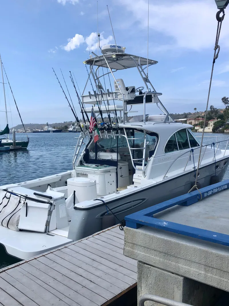 Slide: The Image of 2006 Glacier Bay 3480 Ocean Runner boat docked, equipped with fishing rods. - 2