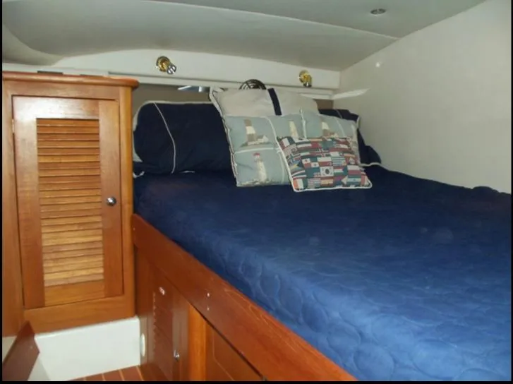 Slide: The Image of 2006 Glacier Bay 3480 Ocean Runner cabin with blue bedding and wooden storage. - 30