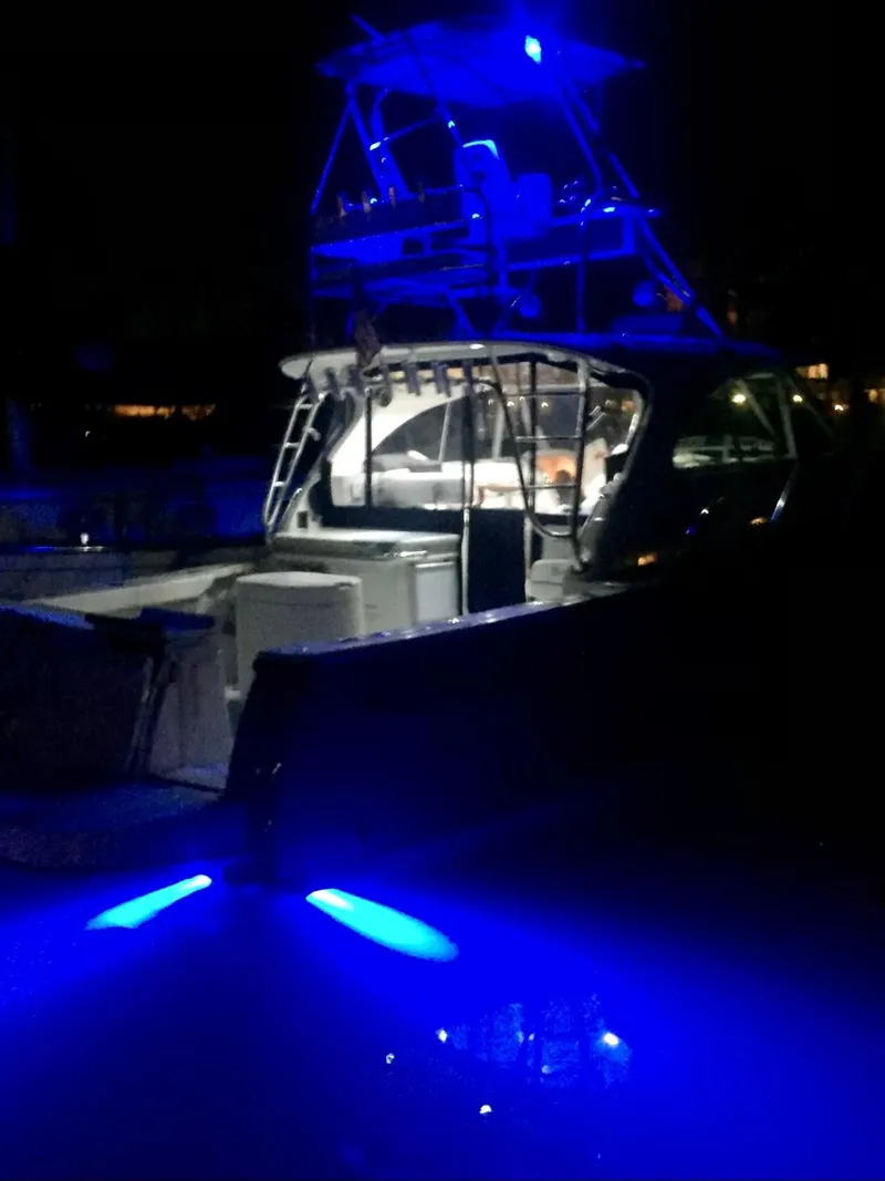 Slide: The Image of 2006 Glacier Bay 3480 Ocean Runner boat illuminated with blue lights at night. - 32