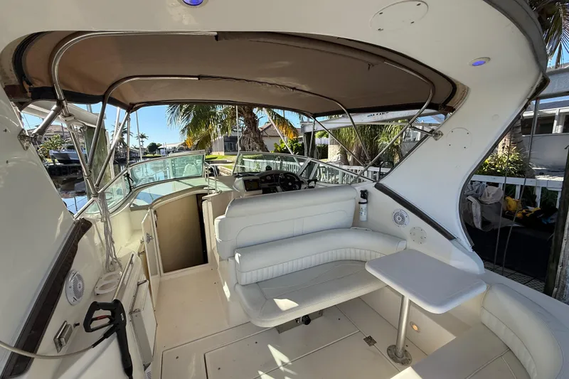 Slide: The Image of 2003 Cruisers Yachts 3075 Express interior with seating, table, and helm under canopy. - 10