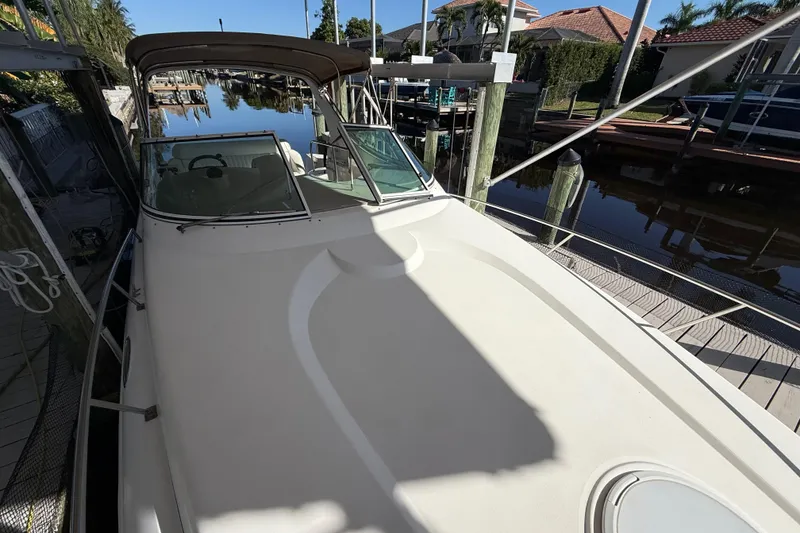 Slide: The Image of 2003 Cruisers Yachts 3075 Express docked in a serene waterfront setting. - 15