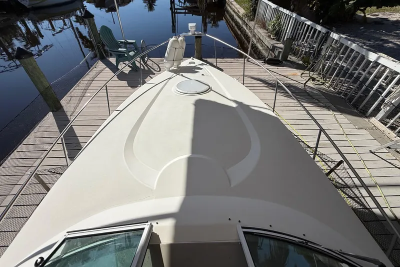 Slide: The Image of 2003 Cruisers Yachts 3075 Express docked at a serene waterfront. - 16