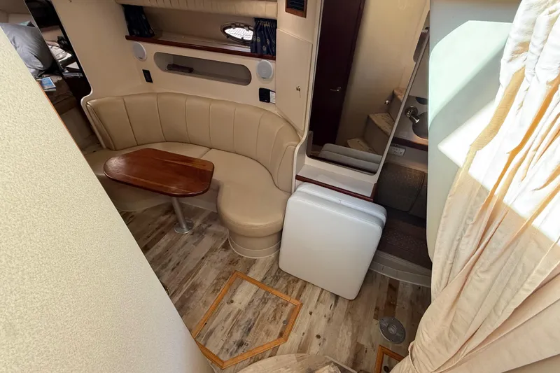 Slide: The Image of Interior of 2003 Cruisers Yachts 3075 Express with seating and wooden table. - 17