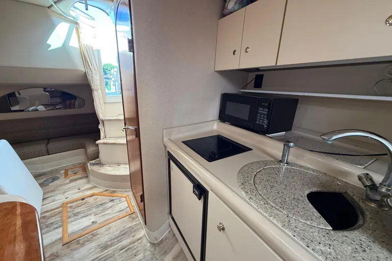 Slide: The Image of 2003 Cruisers Yachts 3075 Express interior with kitchenette, microwave, and seating area. - 19