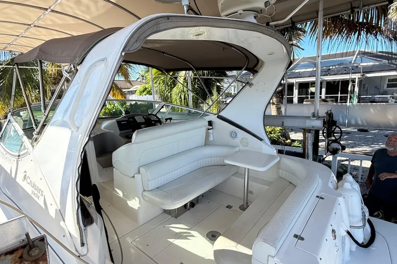 Slide: The Image of 2003 Cruisers Yachts 3075 Express with white seating and canopy, docked near palm trees. - 6