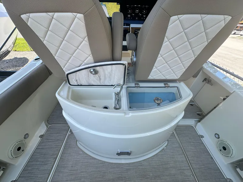 Slide: The Image of 2024 Chris-Craft Catalina 30 boat interior with open storage compartment and cushioned seats. - 9