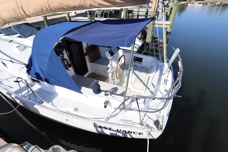 Slide: The Image of Sailboat Nonsuch 260, 1995 model, docked with blue canopy and wooden steering wheel. - 12