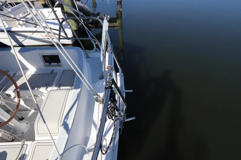 Slide: The Image of 1995 Nonsuch 260 sailboat docked, featuring deck and steering wheel details. - 13