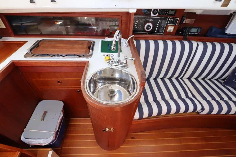 Slide: The Image of Interior of 1995 Nonsuch 260 sailboat with striped seating and compact kitchen area. - 26