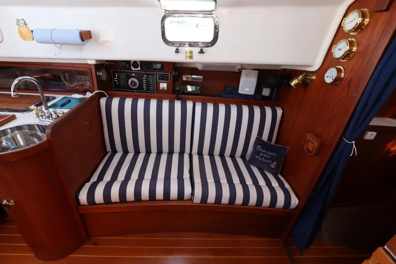 Slide: The Image of 1995 Nonsuch 260 interior with striped seating, nautical decor, and wooden finishes. - 27