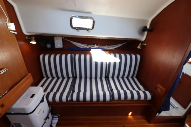 Slide: The Image of Interior of 1995 Nonsuch 260 sailboat with striped seating and wooden accents. - 30