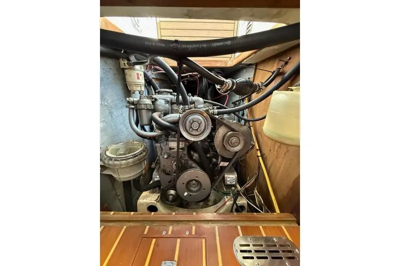 Slide: The Image of Engine compartment of a 1995 Nonsuch 260 sailboat, showcasing mechanical components and wiring. - 38
