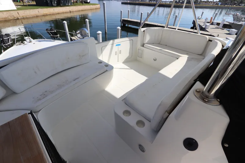 Slide: The Image of 1991 Spectrum 48 Convertible yacht cockpit with white seating, docked at marina. - 10
