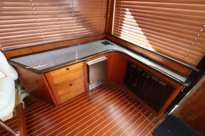 Slide: The Image of Luxurious 1991 Spectrum 48 Convertible yacht interior with wooden cabinetry and blinds. - 17