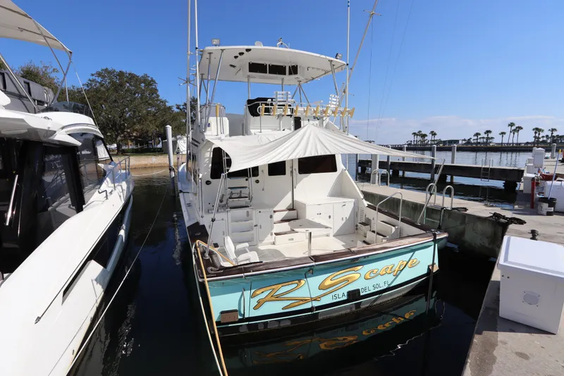Slide: The Image of 1991 Spectrum 48 Convertible yacht docked at marina under clear blue sky. - 2